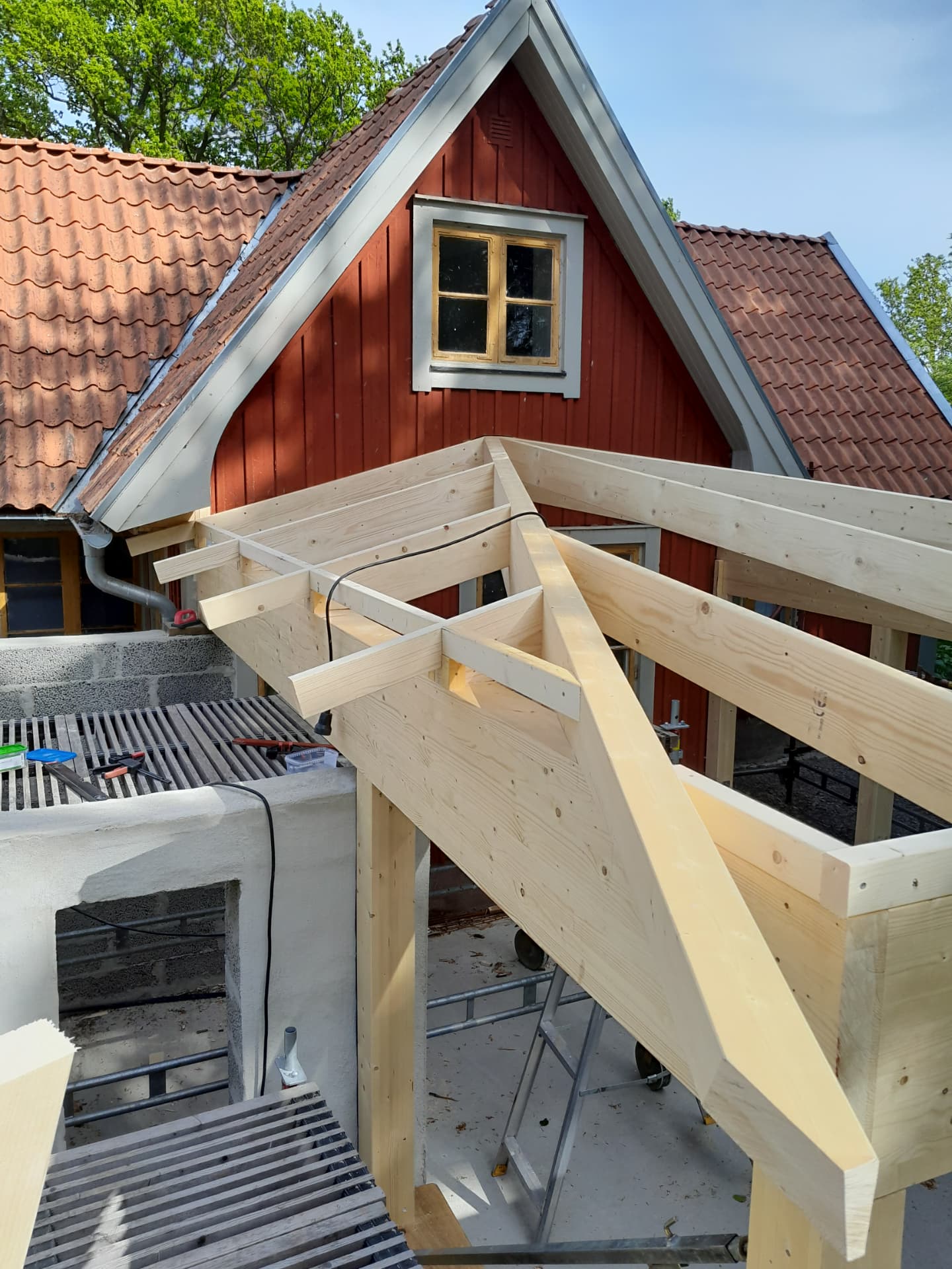 Takstolsarbete vid rött hus — Tillbyggnad